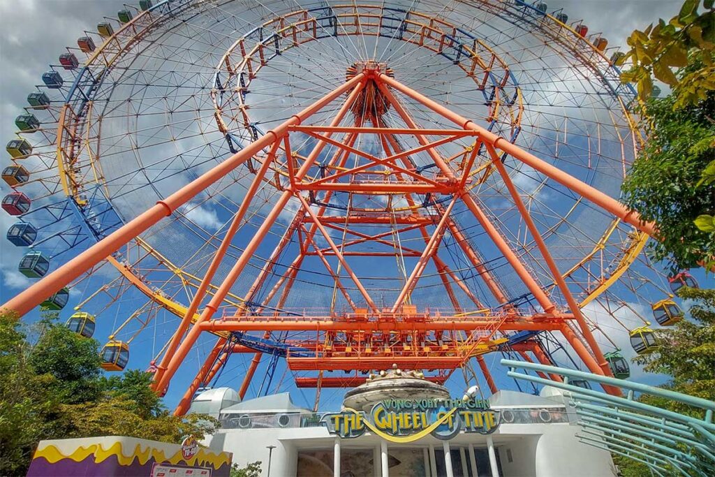 Large Ferris wheel attraction at VinWonders Phu Quoc with colorful cabins and blue sky in the background
