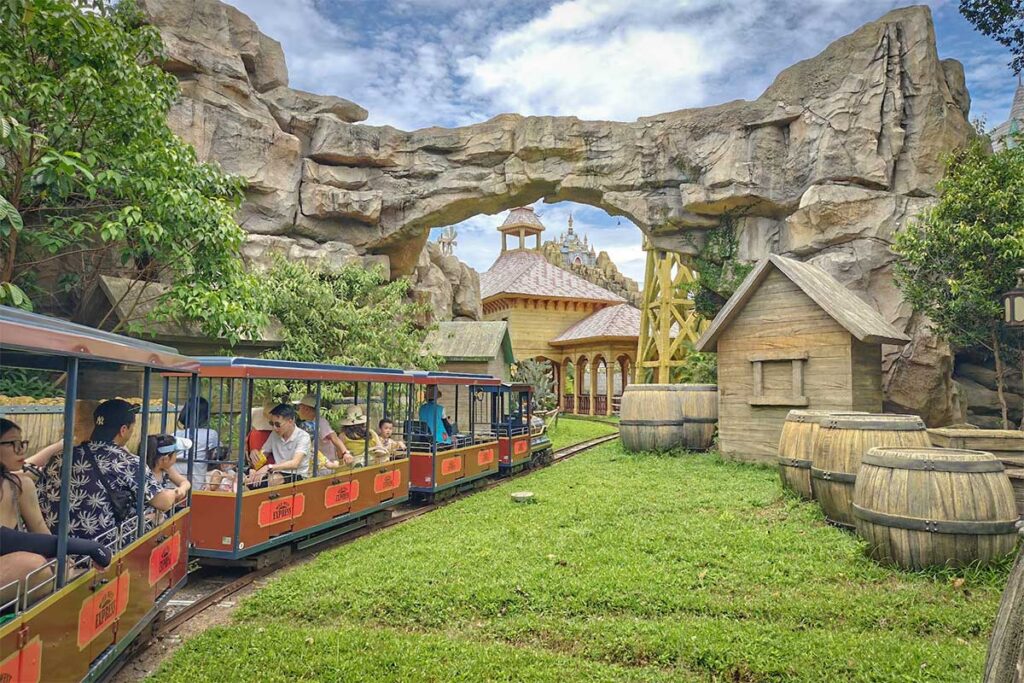 Small adventure train ride passing through themed rock scenery inside VinWonders Phu Quoc amusement park