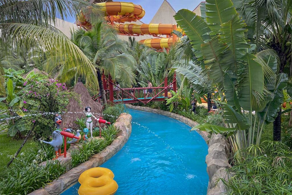 Lazy river surrounded by tropical plants and water slides at Typhoon World water park in VinWonders Phu Quoc