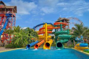 Large colorful water slides at Typhoon World water park in VinWonders Phu Quoc with tropical palm trees and swimming pools