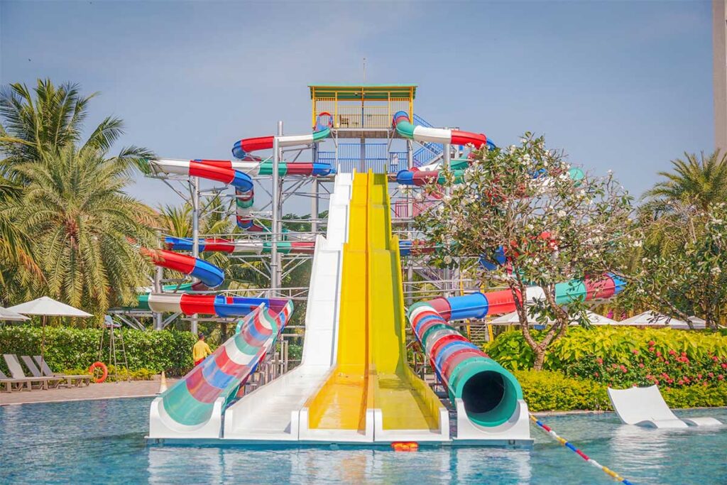 Large water slides and lagoon pool at Wyndham Grand Phu Quoc family resort with tropical palm trees and kids water park area in Phu Quoc Vietnam