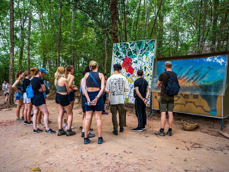 A group of backpackers at the Cu Chi Tunnels part of a group tour from Ho Chi Minh City