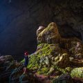 A traveller walking through the dark Bat Cave in Pu Luong