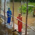Chau Doc tours with Cham women crossing a wooden bridge over the river in An Giang