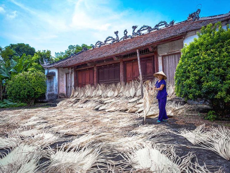 woman crafting traditional conical hats at Chuong Conical Hat Village near Hanoi