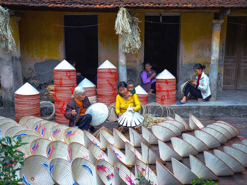 woman crafting traditional conical hats at Chuong Conical Hat Village near Hanoi