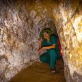 A local tour guide kneeling down inside the Cu Chi Tunnels, one of the best things to do in Vietnam.