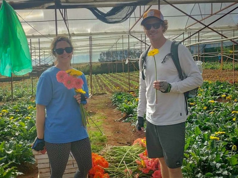 Cycling tour stop at a Dalat flower garden greenhouse, where travelers explore Dalat’s famous flower farming