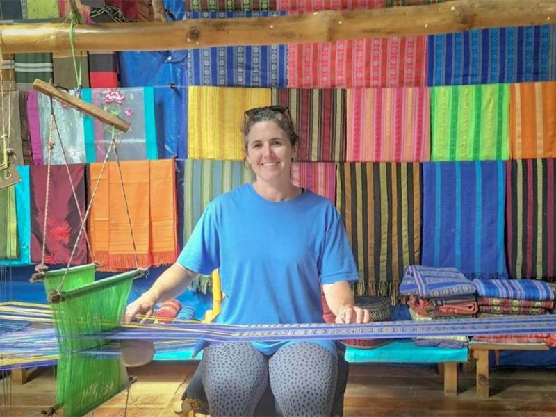 Traveler learning traditional weaving at a local workshop during a cycling tour in Dalat, highlighting cultural experiences in Dalat
