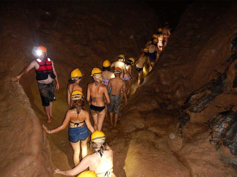 dark cave phong nha 4 A group of travelers walking through a cave tunnel full of mud at the Dark Cave in Phong Nha National Park