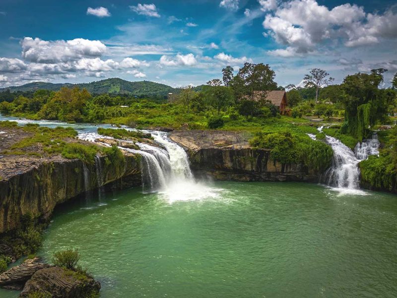 A stunning aerial photograph of Dray Sap Waterfall, revealing its cascading water surrounded by lush greenery.