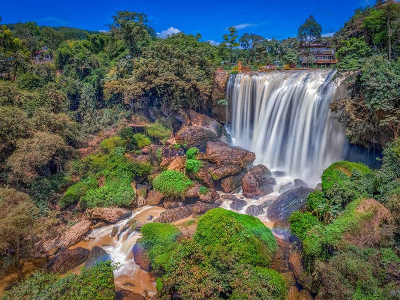 Overview of Elephant Waterfall in Dalat Vietnam showing the full waterfall, forested slopes and river below