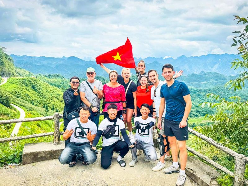 Dutch travelers on a Ha Giang Loop Easy Rider group tour with Local Vietnam, standing with local guides at a mountain viewpoint during a guided motorbike tour in Ha Giang