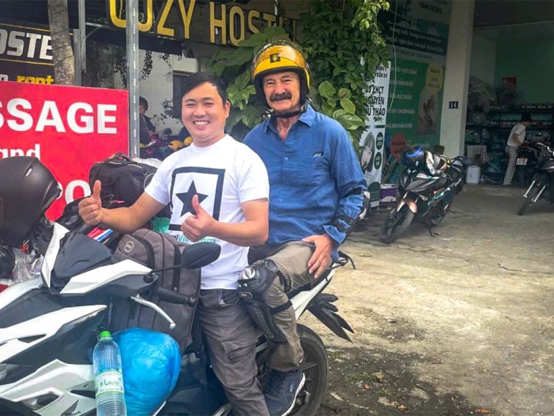 Older traveler riding as a passenger on a Ha Giang Loop Easy Rider tour with a Local Vietnam guide, illustrating that the Ha Giang Loop motorbike tour is suitable for different ages