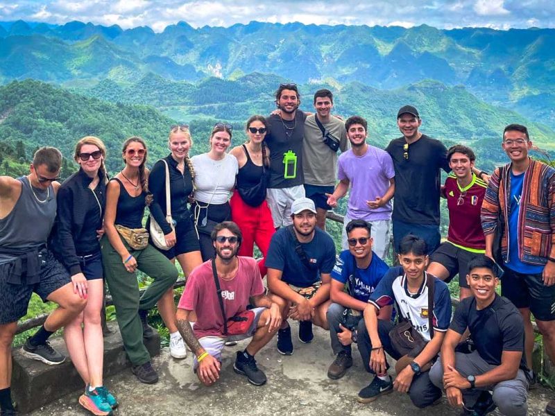 Ha Giang Loop group tour by Easy Rider motorbike with Local Vietnam, showing international guests and local drivers at a panoramic viewpoint along the loop