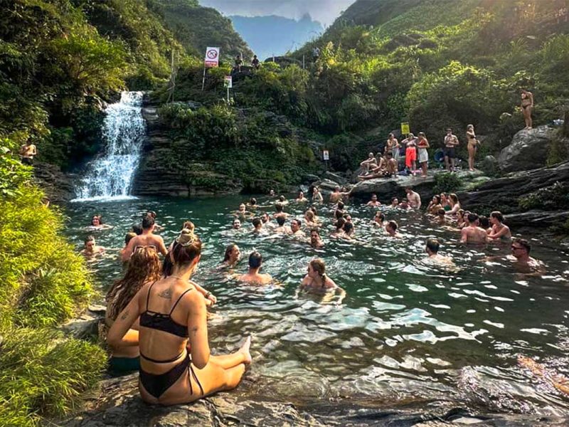 Local Vietnam guests swimming at Du Gia Waterfall during a Ha Giang Loop group tour, enjoying a natural break after traveling the loop by motorbike, car and jeep