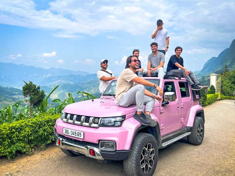 Ha Giang Loop jeep tour experience with Local Vietnam, featuring guests riding on a pink jeep and enjoying panoramic mountain views along the loop