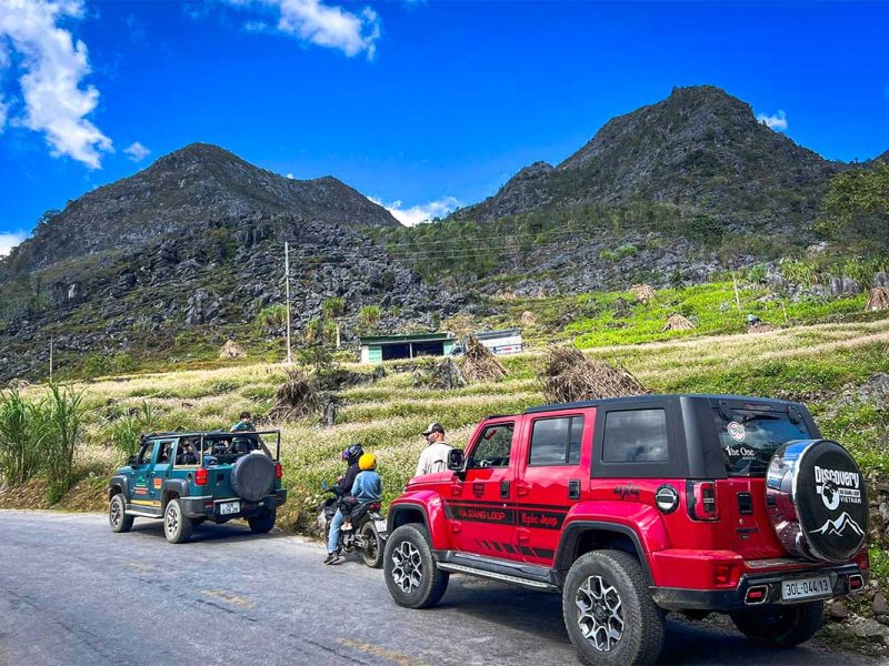 Family-friendly Ha Giang Loop jeep tour with Local Vietnam, showing parents and a child enjoying views from the front of the jeep at a scenic stop
