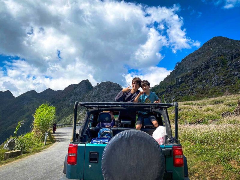 Local Vietnam Ha Giang Loop jeep convoy on a mountain road, combining multiple jeeps and motorbikes during a guided loop itinerary