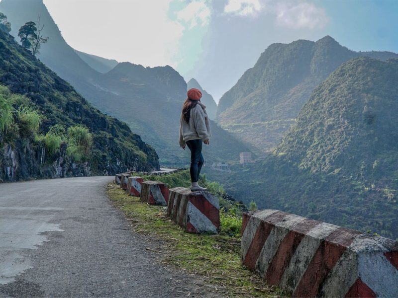 Woman standing along the road at Ma Pi Leng Pass among the famous Ha Giang motorbike Loop