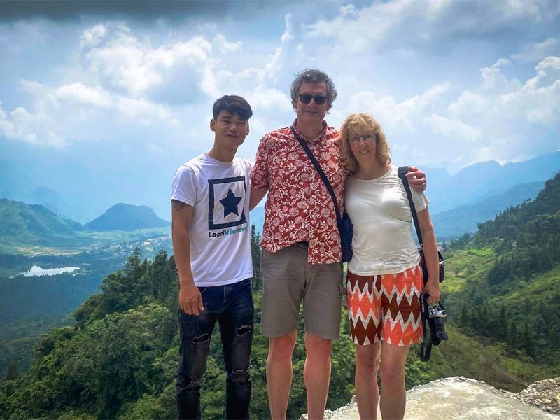 Dutch travelers on a Ha Giang Loop tour with Local Vietnam, posing with a local guide at a scenic viewpoint above terraced fields and mountain landscapes