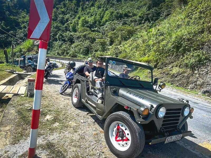 Military jeep driving on a dirt road in Ha Giang during jeep tour