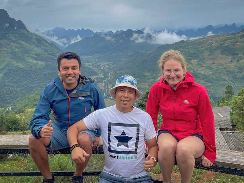 Local Vietnam guide with travelers overlooking the Ha Giang mountains, showcasing the agency’s personalized tours and deep local expertise.