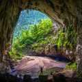 A huge cave opening with jungle inside and small river at Hang En Cave, Phong Nha, Vietnam