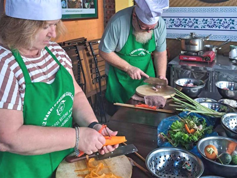 hanoi cooking class 17 Two participants preparing fresh vegetables as part of a cooking class in Hanoi
