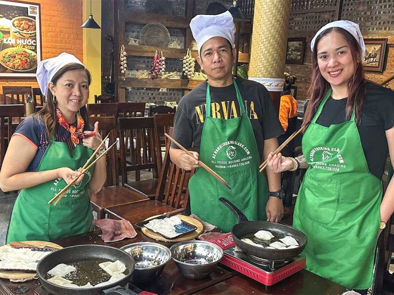 hanoi cooking class 7 Chef teaching two tourists how to prepare Vietnamese dishes during a cooking class in Hanoi