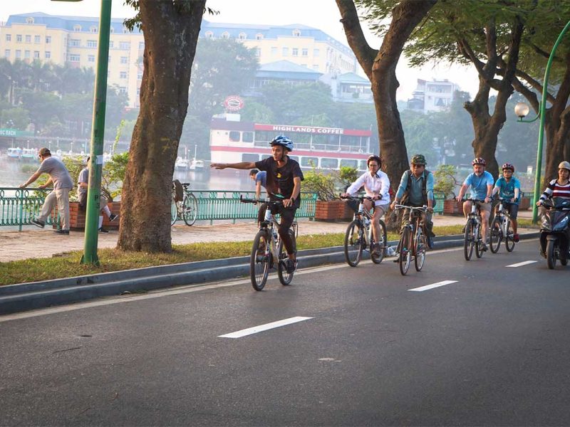 hanoi cycling tour 3 Tourists and guide biking along West Lake during a Hanoi cycling tour