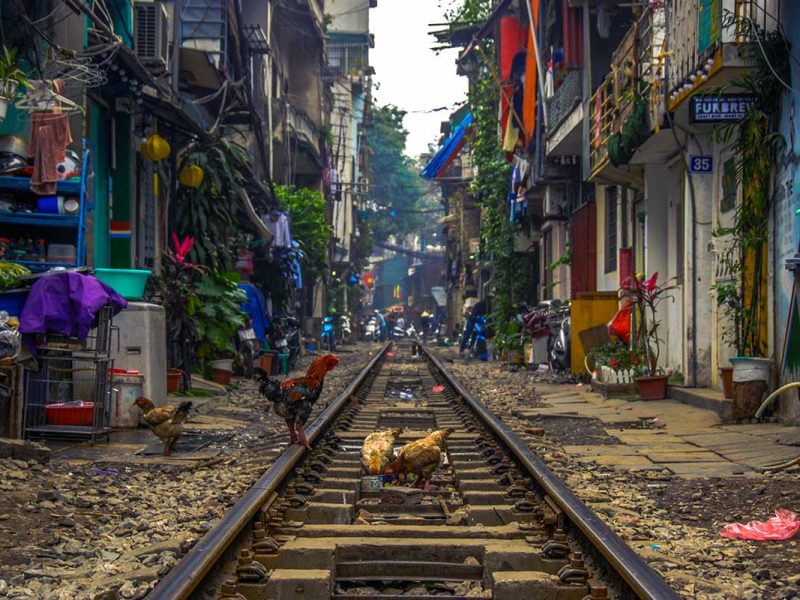 hanoi train street 3 Hanoi Train Street: A train rumbles through the narrow Hanoi Train Street, passing between vibrantly colored houses.