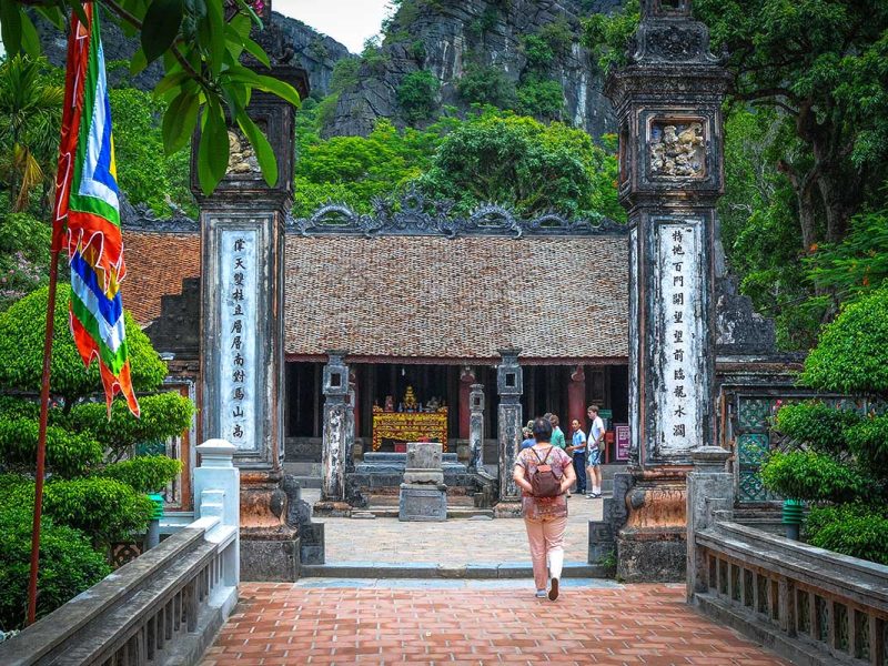hoa lu ancient capital 2 Visitor approaching the tiled-roof entrance hall of Dinh Tien Hoang Temple past festival flags, Hoa Lu Ancient Capital, Ninh Binh