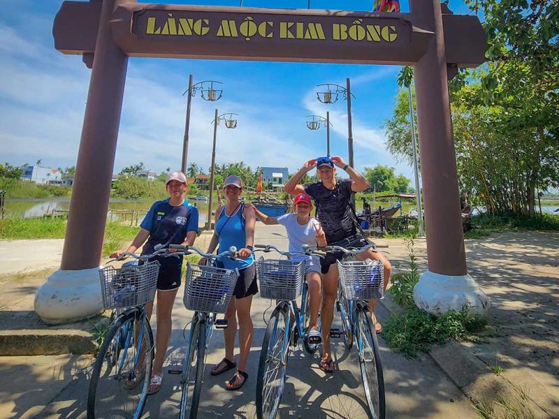 Hoi An Cycling Tour – group photo at the entrance of Kim Bong carpentry village on Cam Kim Island