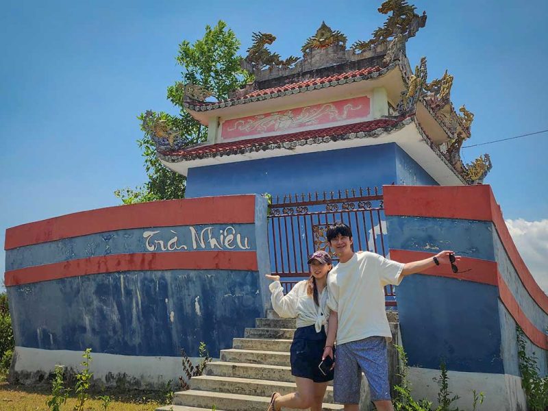 Couple posing in front of the Tra Nhieu village gate while cycling through the countryside on the Hoi An tour