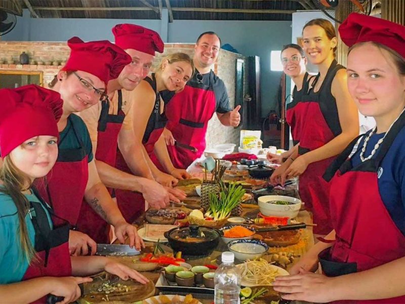 Family preparing Vietnamese dishes at Hoi An Tropical Cooking Tour
