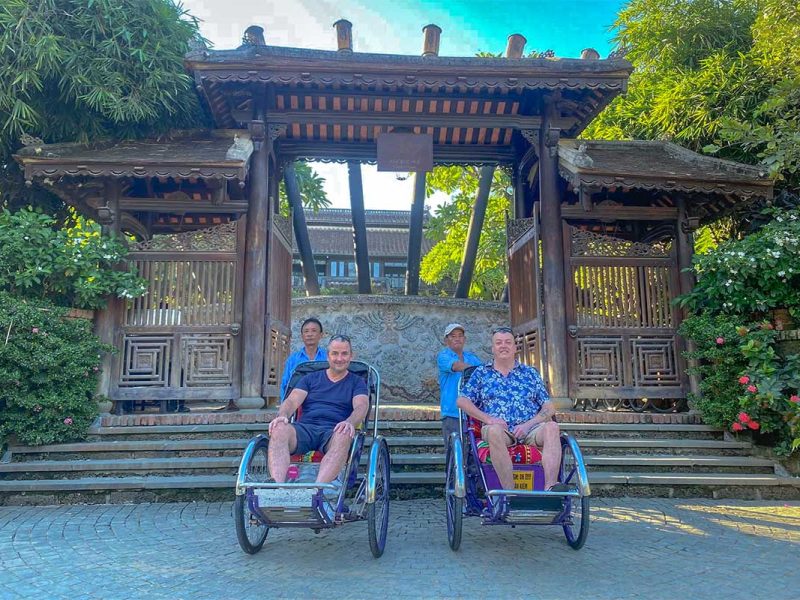 Two tourists both on their on cyclo with local rider doing a Hue food tour by cyclo