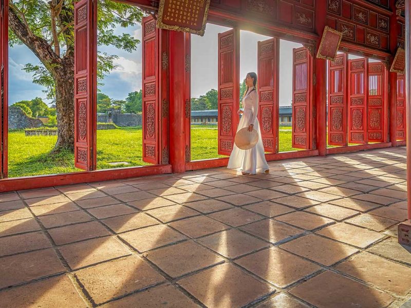 Woman walking through the Imperial City in Hue, a peaceful and romantic cultural site in central Vietnam.