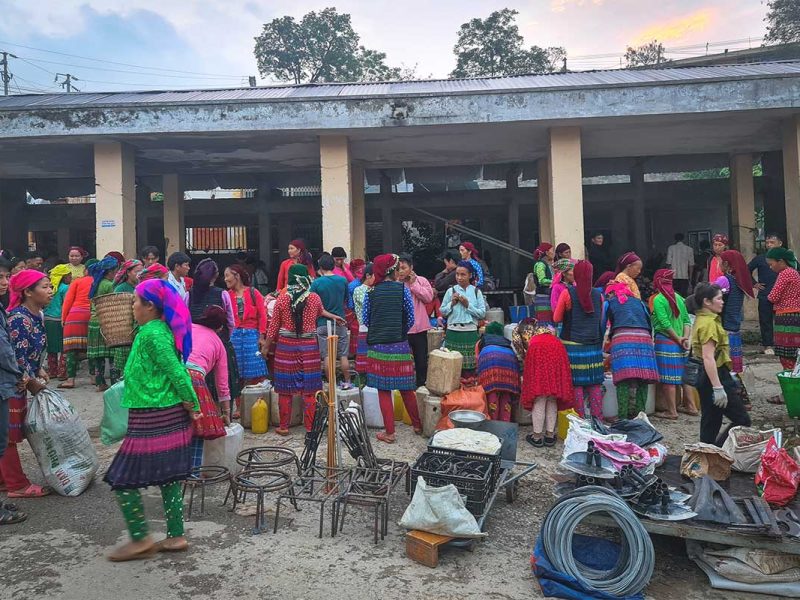 A bustling local market in Khau Vai, filled with colorful ethnic minorities selling and trading goods.