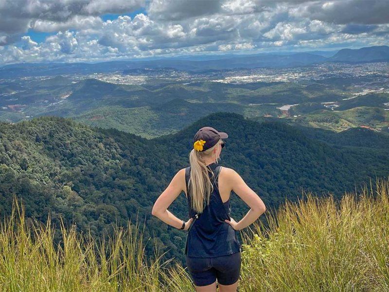 Hiker standing at a panoramic viewpoint during a Langbiang Mountain trekking tour, with sweeping views over the Central Highlands near Dalat.