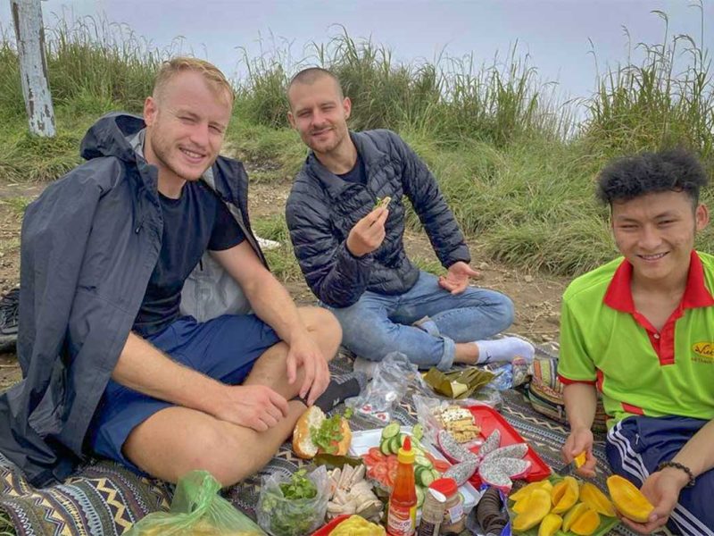 Picnic lunch stop during a Langbiang Mountain trekking tour, with travellers enjoying local food at a scenic viewpoint near Dalat.