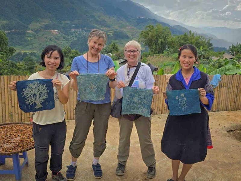 Mu Cang Chai batik workshop tour with travelers proudly holding their handmade indigo batik pieces