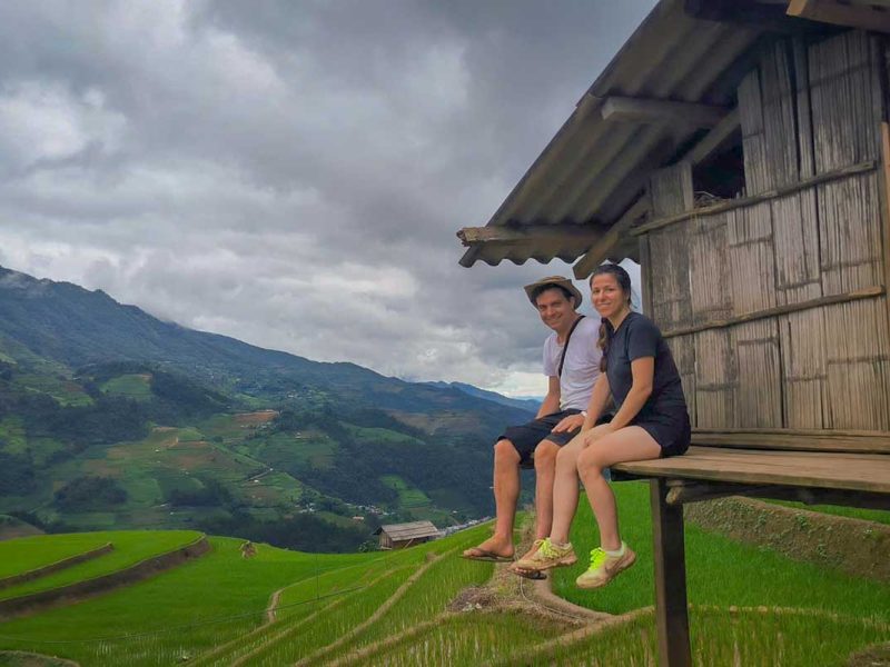 Mu Cang Chai tour experience with travelers relaxing at a wooden hut overlooking terraced rice fields