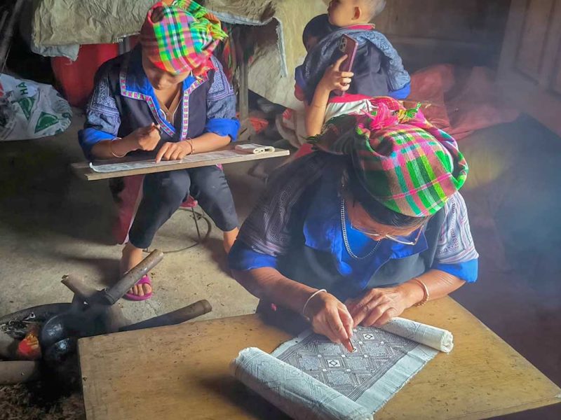 Mu Cang Chai tour batik workshop with Hmong women creating traditional patterns inside a local home