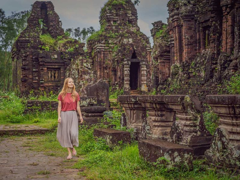 my son sanctuary 11 Traveler walking through the My Son Sanctuary ruins, highlighting the scale and quiet atmosphere of the ancient site.