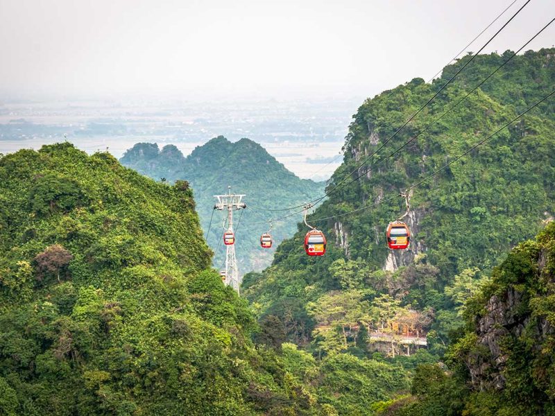 Cable cars passing through mountain scenery en route to the Perfume Pagoda near Hanoi
