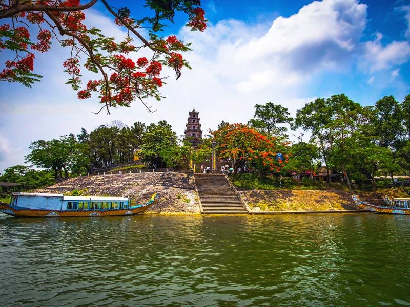 Two dragon boats parked on the Perfume River in front of the Thien Mu Pagoda in Hue.