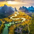 Aerial view of Phong Nam Valley with a river running through a valley surrounded by rice fields and mountains.
