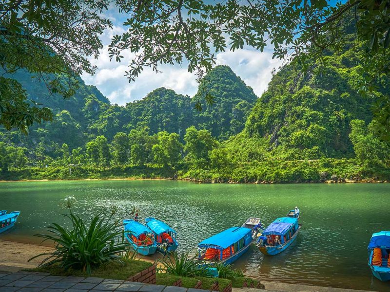 Boats docked on the river banks near Phong Nha Cave