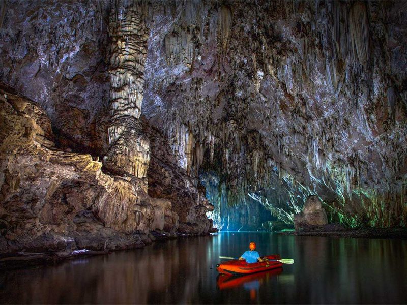 A man kayaking solo through Phong Nha Cave